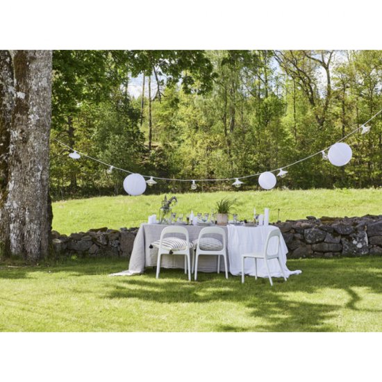 Miljöbild sommarbild på utomhusdekorationer med vacker dukning i trädgården. Vaxljusdekoration