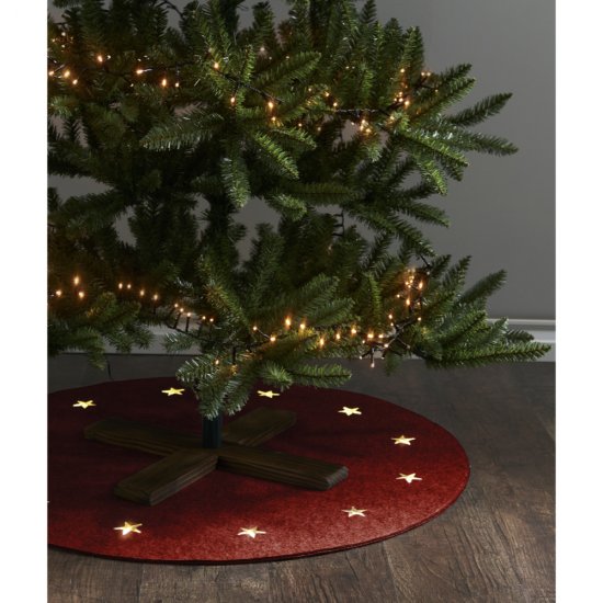 Julgransfot Granig i trä under en gran med röd matta